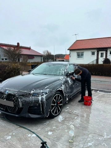 Svart BMW M-serie under aktiv skumtvätt vid kundens hem